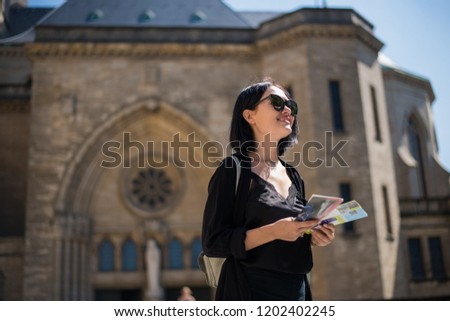 Stylish women in a black dress walking around the streets of the old city of Luxembourg. A tourist girl strolling through the old city.