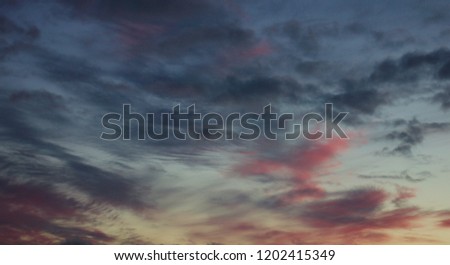 Blue and orange sky with wavy blue and pink sunset clouds