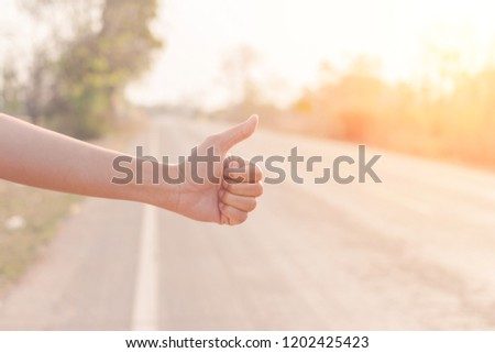 hand hitching car on road