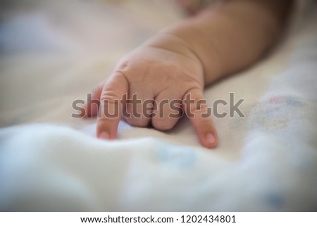 Photo of newborn baby hand with fabric cartoon pattern