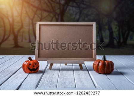 Halloween background. Spooky pumpkin, Black spider, chalkboard on white wooden floor with moon and dark forest. Halloween design with copyspace