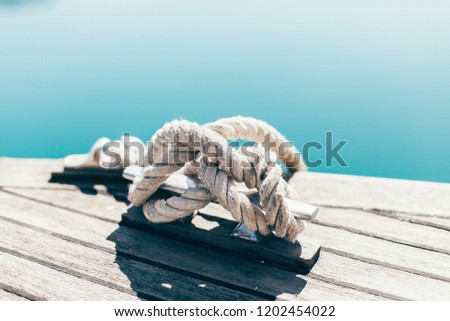 vintage rope from yacht on a wooden tick background with sunlights in sea