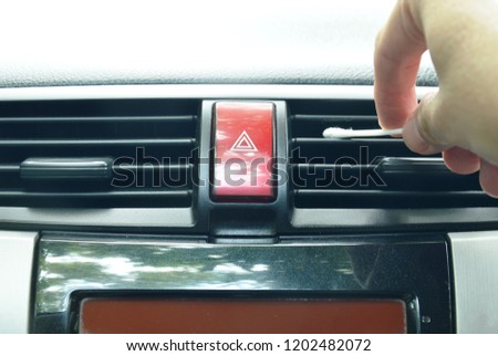 hand use cotton bud cleaning air conditioner hole in car 