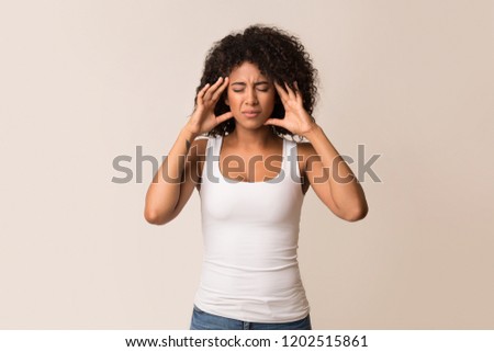 African-american girl suffering from headache over light background