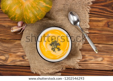 Pumpkin soup on a wooden table.