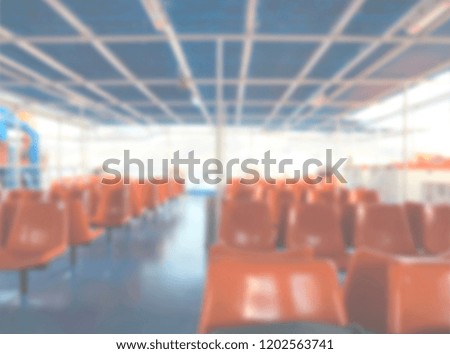 Defocused background of empty orange seats in a boat during a summer trip to Greek islands. Intentionally blurred post production for bokeh effect.