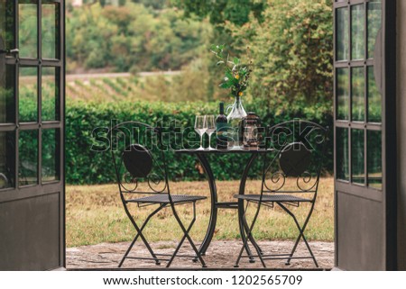 Table served for a romantic evening with an overview of the Tuscan hills and vineyards on the outdoor terrace near  Italian agriturismo. Royalty-Free Stock Photo #1202565709