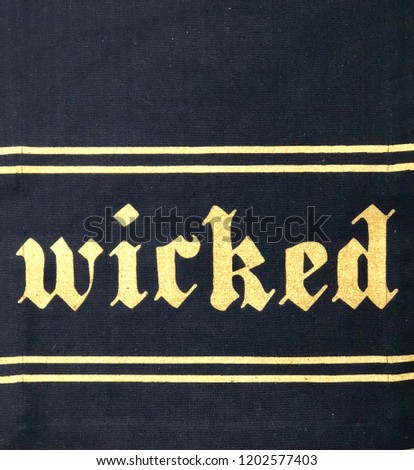 Close-up of black and gold halloween banner with the word wicked
