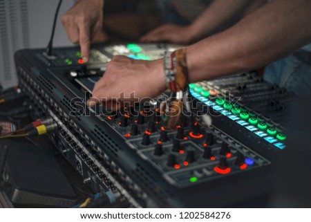 DJ tuning sound electronic equipment before a musical performance