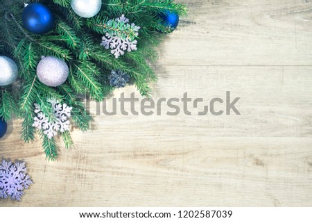 Christmas firtree with holly, snowfall on wooden white board