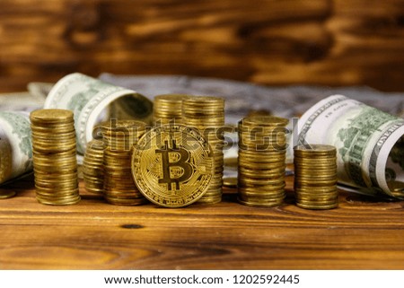 Golden bitcoin and dollars on wooden background