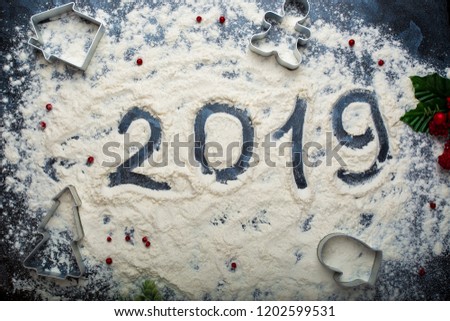 inscription 2019 on spilled flour on a dark background
