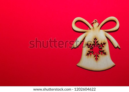 Christmas wooden toy bell on a red background