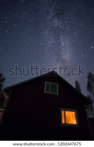 Milky Way and stars above country house.