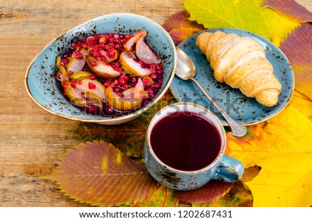 Hot tea, croissant, autumn maple leaves. Studio Photo