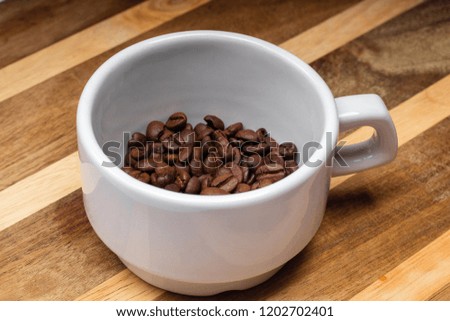 white cup of grain coffee on a saucer on the wooden background surface