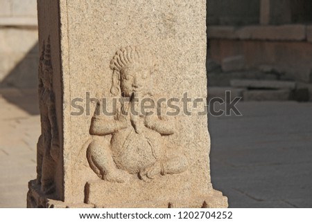 Stone bas-reliefs on the column in Temples Hampi. Carving stone ancient background. Carved figures made of stone. Unesco World Heritage Site. Karnataka, India. Stone background.