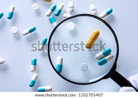medications under a magnifying glass Royalty-Free Stock Photo #1202705407