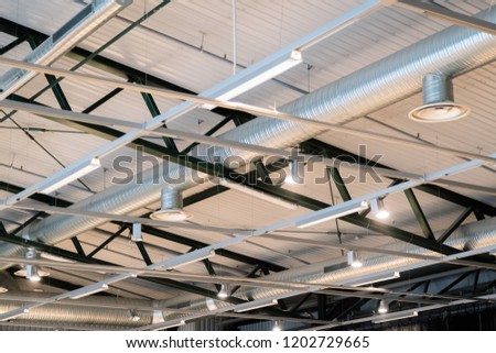 Factory building or warehouse building. Vast empty space with ventilation pipes and lights