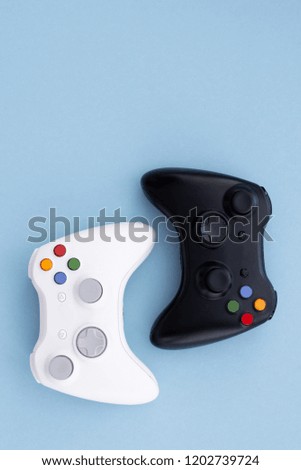 White and black joystick on a pastel blue background. Gamer concept. Controller for video games. Gamepad is isolated on a yellow background. Gaming competition. Copyspace. Flatlay