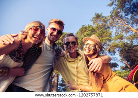 A group of young people friends make selfies outdoors. Summer, vacation, fun, friendship concept