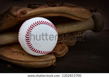 VIntage baseball glove ans baseball ball on wood background.