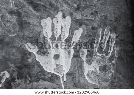 Hands prints over a dark concrete wall background