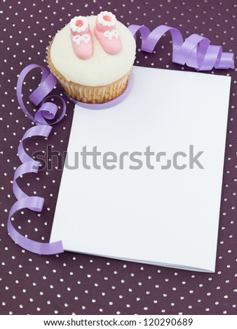 muffin with  pink slippers in corner white frame paper  decorative and purple ribbon