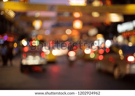 Abstract blurred traffic and people walking on the road with colorful bokeh light background in the city