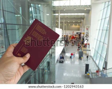 Female caucasian hand holding a Belgian passport in the Connector building of Brussels Airport, Belgium's main airport. Royalty-Free Stock Photo #1202943163