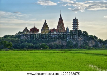 Landscape​ of​ Wat​ Tham​ Sua​ thai temple​ in Kanchanaburi, Thailand. Wat​ Tham​ Sua​ temple​ is a rice​ field​ around.