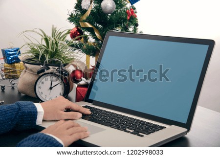 Business hand using computer blank screen mockup on desk. Concept Office Christmas and Happy new year.