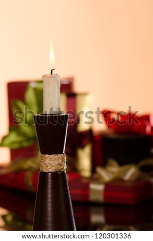 Candle and gifts boxes against orange background