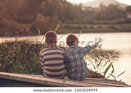 children sit on a demolished fishing pier