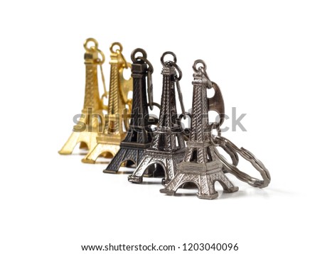 A line of traditional French Souvenirs-key chains in the form of the Eiffel tower, isolated on a white background