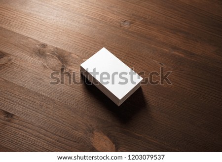 Stack of blank business cards on wood table background.