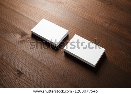 Mockup of blank business cards on wooden background.