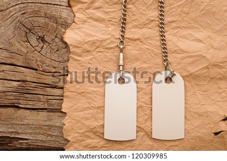 blank tags with silver chain on vintage background. space for your text