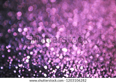 Abstract background with bokeh blurred lights. Shimmering bright red, purple, violet sequins on a dark. The picture creates and accentuate a festive magical mood. New year, Christmas, Valentine's day.