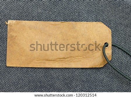 paper price tag with cord over blue fabric