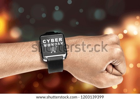 Digital wrist watch with Cyber Monday message against blurred lights background
