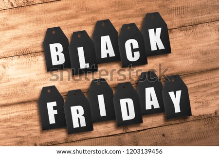 Text of Black Friday from black sale tags on wooden table