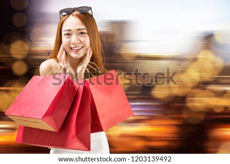 Beautiful chinese woman caryying red shopping bags. Black friday concept
