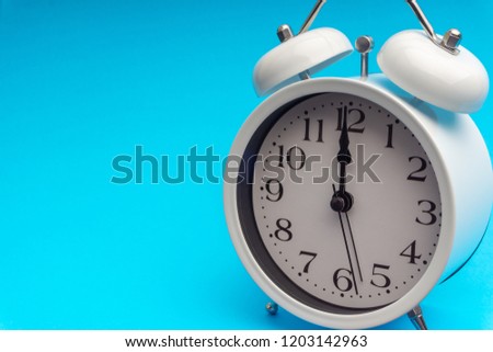 Clock on blue background with selective focus and crop fragment. Copy space concept