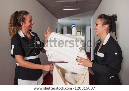 Two chambermaid women talking together during service in a hotel. Royalty-Free Stock Photo #120315037
