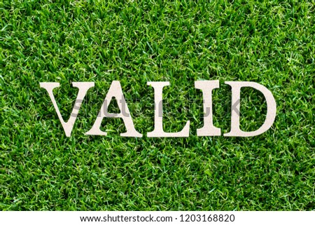 Wood letter in word valid on artificial green grass background