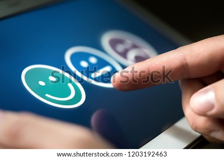 Survey, poll or questionnaire for user experience or customer satisfaction research. Quality control and feedback concept. Man choosing his opinion with smiley faces on touch screen. Royalty-Free Stock Photo #1203192463
