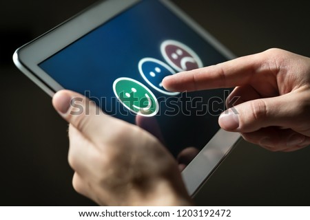 Man using tablet to give review, opinion and feedback to survey, poll or questionnaire for user experience or customer satisfaction research. Technology for service quality control. Rating concept. Royalty-Free Stock Photo #1203192472