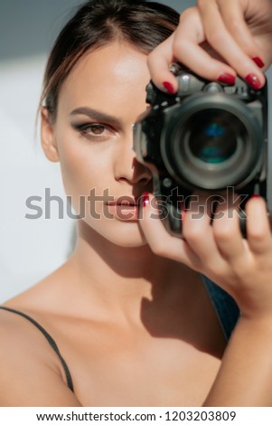 Portrait of a photographer covering her face with the camera. Isolated on a white background. Photographer, Camera, Women. Say cheese! Professional female photographer