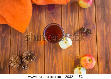 Cup with tea on an autumn background of fallen leaves, apples and grapes.Autumn postcard